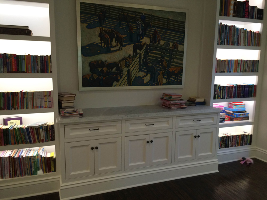 Custom bookcase with lights on shelves holmby Residence